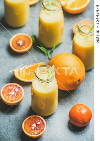 Healthy yellow smoothie in bottle over concrete Healthy yellow smoothie in bottle over concrete 35448474