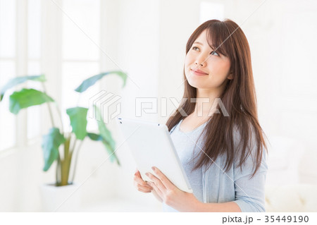 部屋でタブレットを見る女性 部屋でタブレットを見る女性 35449190