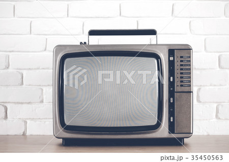 Old television on a white brick wall background. 35450563