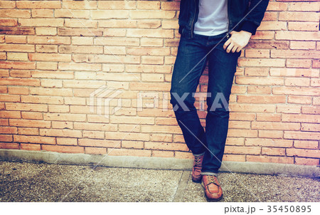 Smart man standing front a wall background. Smart man standing front a wall background. 35450895