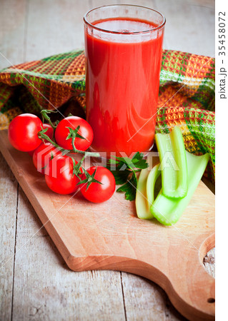 tomato juice in glass, fresh tomatoes and green celery tomato juice in glass, fresh tomatoes and green celery 35458072