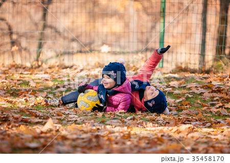 The two little baby girls playing in autumn leaves 35458170