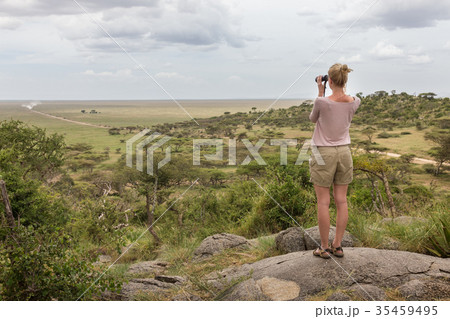 Female tourist looking through binoculars on 35459495