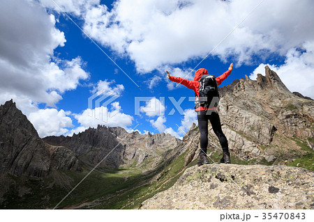 cheering woman with backpack hiking in mountains cheering woman with backpack hiking in mountains 35470843