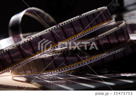 Old film with a movie on a dark background Old film with a movie on a dark background 35473753