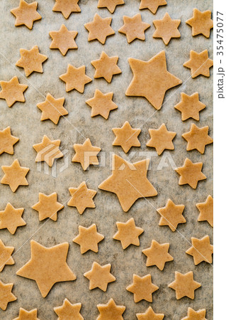 Pattern of stars shaped cookies on parchment paper Pattern of stars shaped cookies on parchment paper 35475077