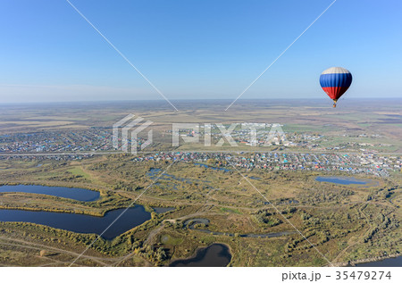 Flight of hot air balloon over rural landscape 35479274
