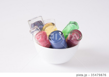many colored bottles of nail polish in cup closeup 35479876