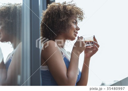 Cheerful african woman drinking cup of coffee Cheerful african woman drinking cup of coffee 35480997