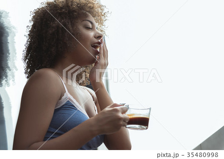 Outgoing girl tasting mug of coffee Outgoing girl tasting mug of coffee 35480998