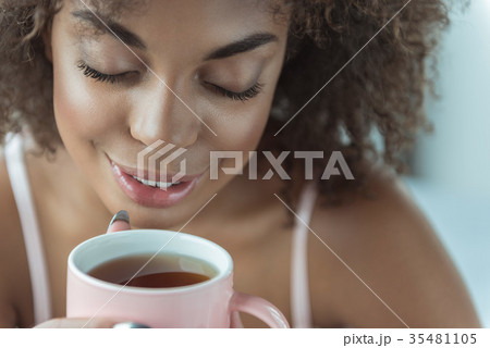 Outgoing woman tasting cup of tea Outgoing woman tasting cup of tea 35481105