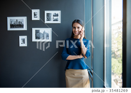 Charming cheerful business lady is talking on Charming cheerful business lady is talking on 35481269