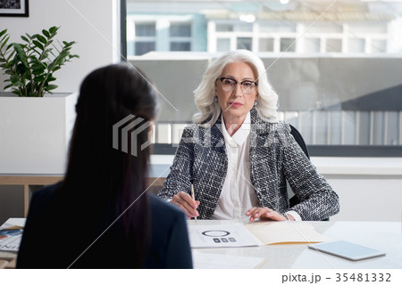 Confident serene senior woman listening to her Confident serene senior woman listening to her 35481332