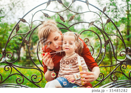 mother and daughter blow bubbles 35485282