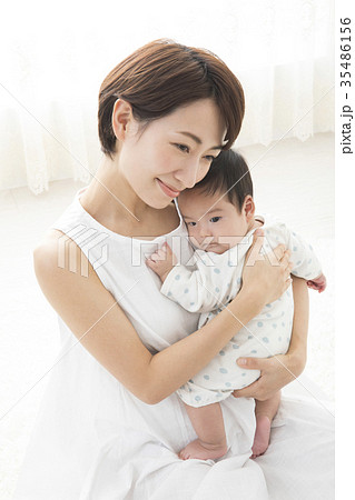 赤ちゃんを優しく抱く女性の写真素材