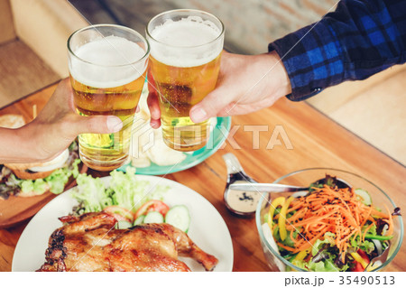 Young man drinking beer and clink glasses happy Young man drinking beer and clink glasses happy 35490513
