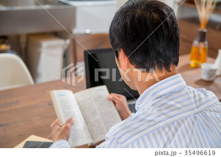 読書をする中年男性　ミドル世代　中高年　短髪の男性　カジュアル　普段着　男の人 35496619