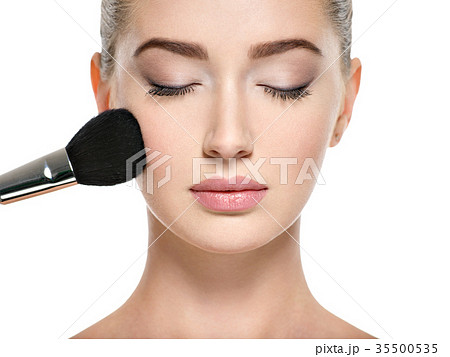 Young girl  with makeup brush near at face 35500535