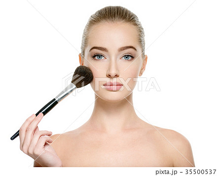 Young girl  with makeup brush near at face 35500537