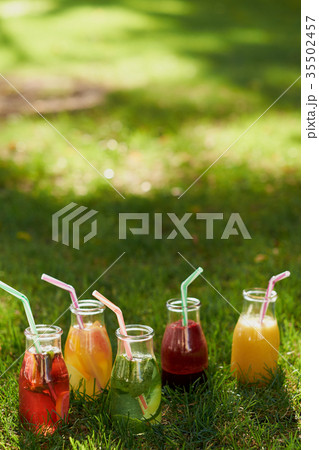 Healthy detox colourful drinks on green grass 35502457