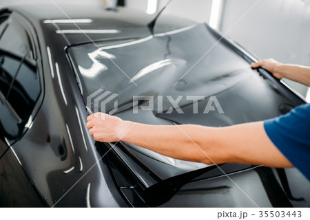 Male specialist with car tinting film in hands 35503443