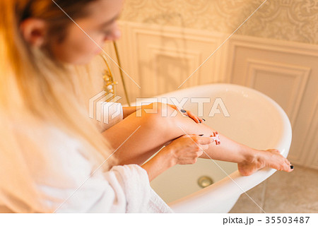 Female person shaves legs in bathroom 35503487