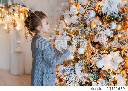 Young girl decorating Christmas tree Young girl decorating Christmas tree 35503670