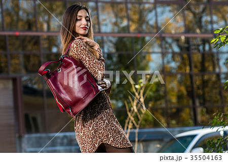 beautiful young woman posing with a leather bag in beautiful young woman posing with a leather bag in 35504163