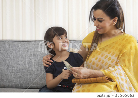 Mother giving pocket money to her daughter 35505062