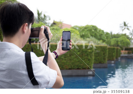Man tourist with compact camera and cell phone  35509138