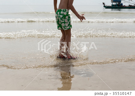 Little boy having fun jumping on the beach  35510147