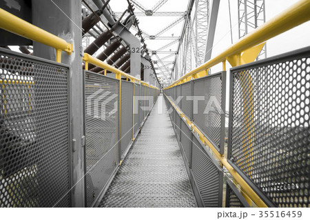 yellow railing of a transportation bridge 35516459