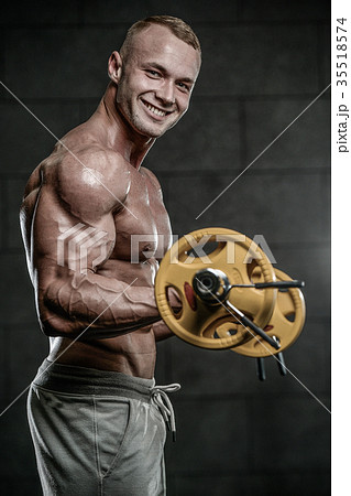 Handsome model young man training arms in gym Handsome model young man training arms in gym 35518574