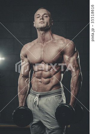 Handsome model young man training abs in gym Handsome model young man training abs in gym 35518616