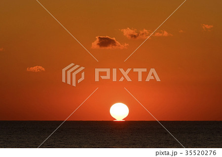 水平線に沈む太陽の写真素材