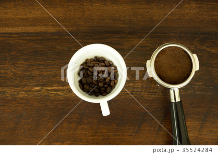 Ground coffee in porta filter holder and beans  35524284