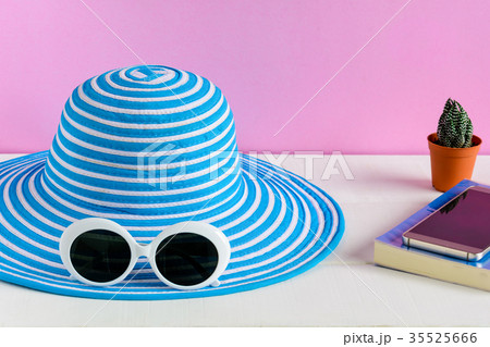 Blue hat and white sunglasses pink wall background Blue hat and white sunglasses pink wall background 35525666