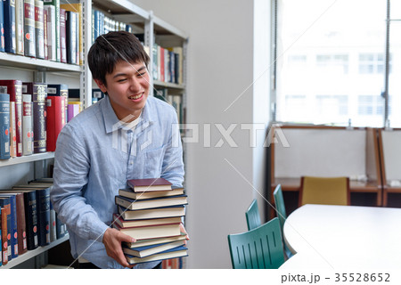 図書館で山積みの本をもつ学生 図書館で山積みの本をもつ学生 35528652