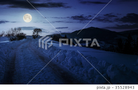 countryside road uphill in snow at night 35528943