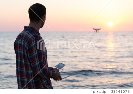 man launches a drone on the beach man launches a drone on the beach 35541078