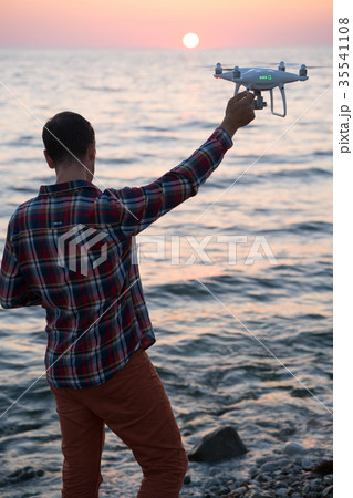 man launches a drone on the beach man launches a drone on the beach 35541108