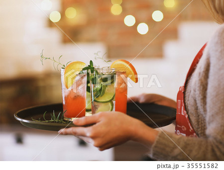 Young pretty woman with cocktails on tray 35551582