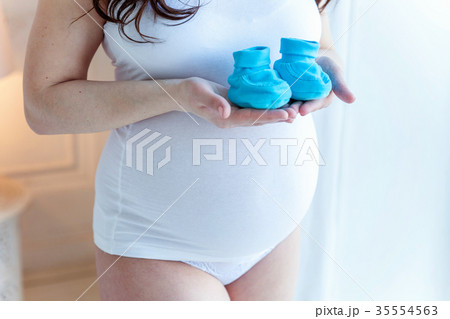 Pregnant girl keeps socks for baby 35554563