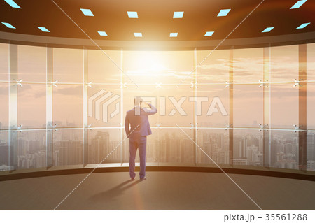 Businessman in front of office window thinking of 35561288