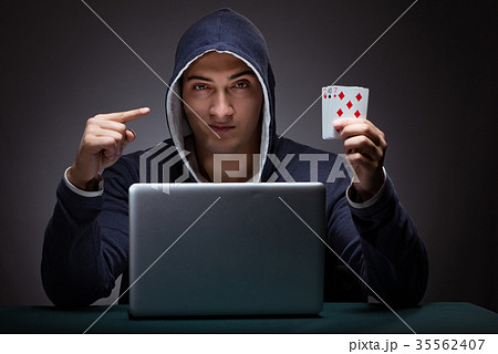 Young man wearing a hoodie sitting in front of a 35562407