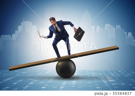 Businessman trying to balance on ball and seesaw Businessman trying to balance on ball and seesaw 35564837