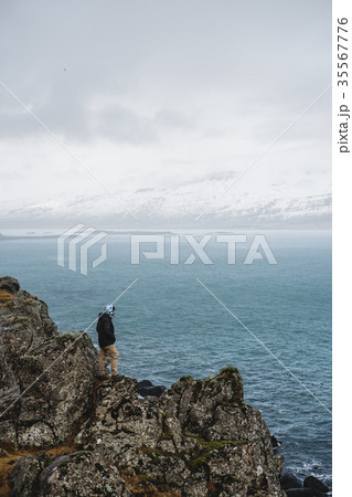 a Man standing on cliff in rainy day 35567776