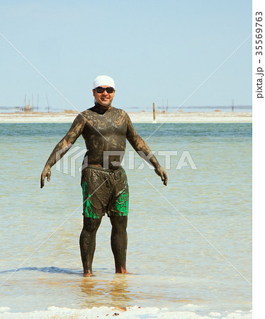 man takes a mud bath in the salty lake Baskunchak 35569763