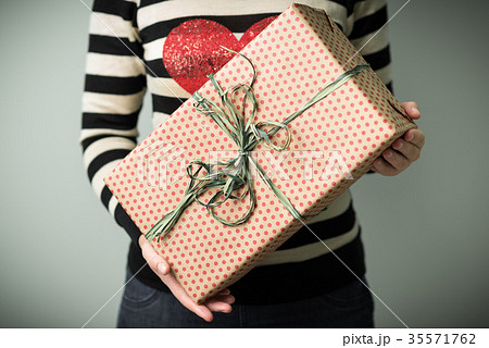 A girl holding a box with a Christmas present 35571762