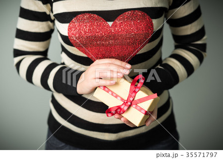 A girl holding a box with a Christmas present 35571797